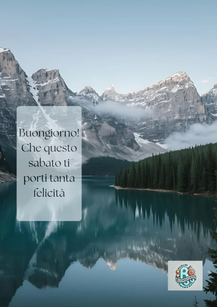 Lago alpino calmo con montagne innevate e foresta di pini, con il testo “Buongiorno! Che questo sabato ti porti tanta felicità.
